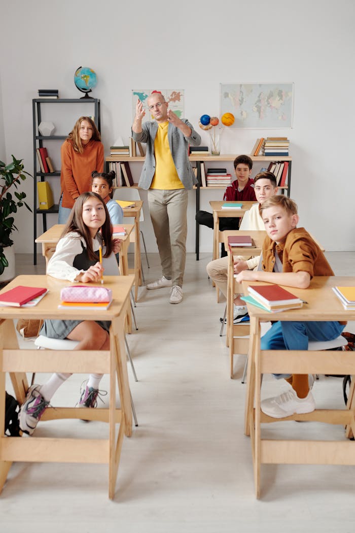 ours-journey Teacher interacting with diverse group of students in modern classroom setting.