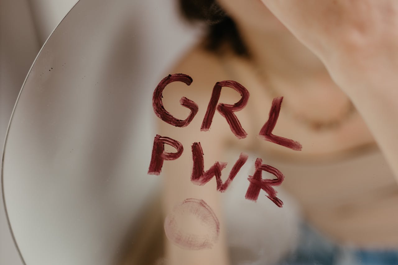hero-img-01 Close-up of empowering 'GRL PWR' message written on a mirror with lipstick.